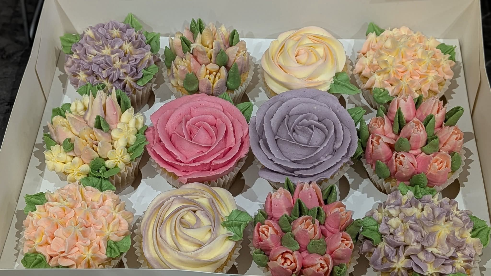 Box of hand-piped floral cupcakes